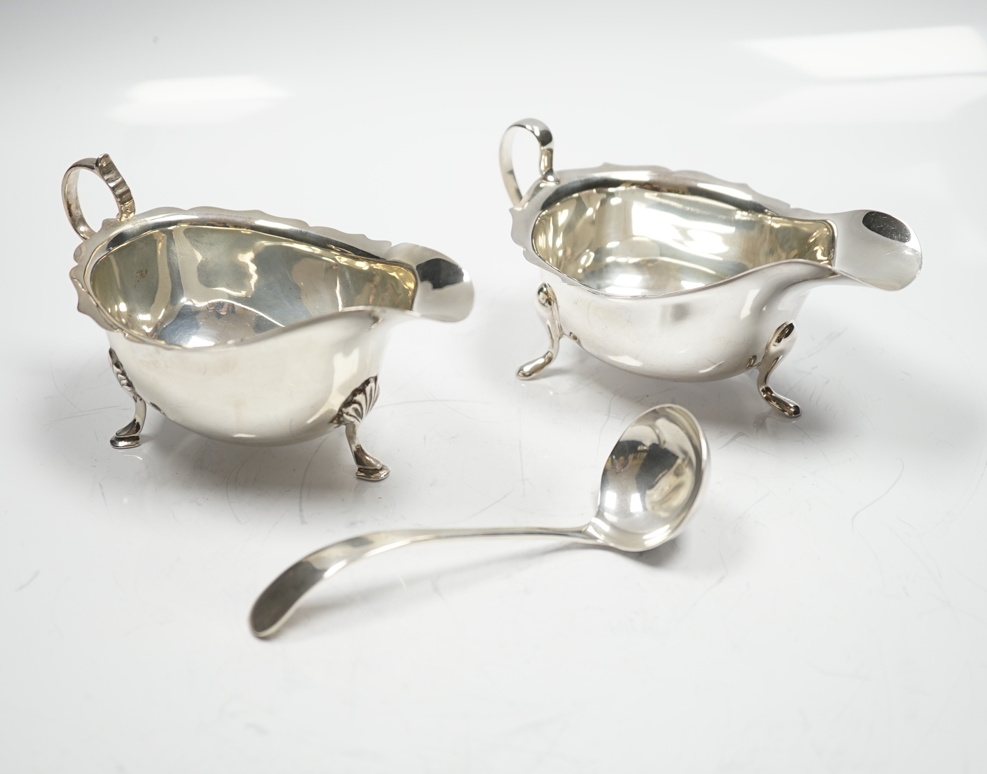 Two mid 20th century silver sauce boats and a similar silver sauce ladle, 8.1oz.